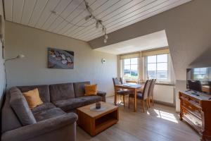 a living room with a couch and a table at Hus-Pellworm-2-Ferienwohnung-Meereswelle in Pellworm