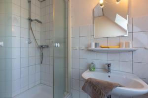 a bathroom with a shower and a sink and a mirror at Hus-Pellworm-2-Ferienwohnung-Meereswelle in Pellworm +16 photos