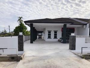 a small white house with a driveway at Homestay Sri Aman in Simanggang