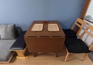 a wooden desk with two chairs and a bed at Tasogare Baycity in Hakodate