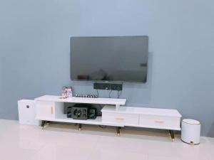 a white entertainment center with a tv on a wall at Homestay Sri Aman in Simanggang