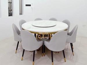 a table with white chairs and a white plate on it at Homestay Sri Aman in Simanggang