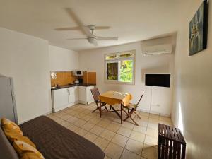 a living room with a table and a kitchen at Orchidée in Capesterre-Belle-Eau
