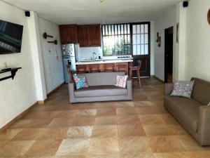 a living room with a couch and a kitchen at Cabaña Barichara in Barichara