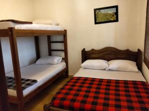 two bunk beds in a room with a checkered blanket at Cabaña Barichara in Barichara
