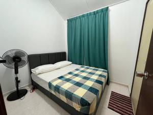 a bedroom with a bed with a green curtain and a fan at Sweet Roses Homestay- Free WiFi, Nearby UiTM in Bandar Puncak Alam