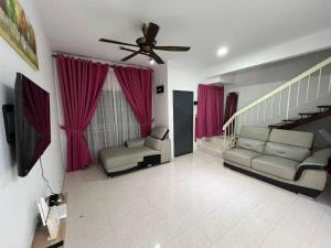 a living room with two couches and a ceiling fan at Sweet Roses Homestay- Free WiFi, Nearby UiTM in Bandar Puncak Alam