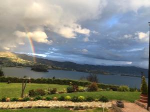 a rainbow in the sky over a lake at Refugio Lago de Tota in Cuítiva +19 photos
