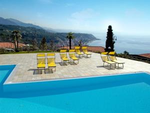 a group of yellow chairs and a swimming pool at Apartment in Cogoleto with pool in Cogoleto