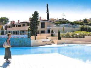 a woman is standing next to a swimming pool at Apartment in Cogoleto with pool in Cogoleto