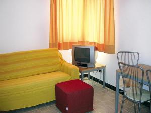 a living room with a couch and a table with a tv at Apartment in Cogoleto with pool in Cogoleto