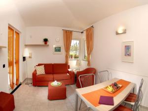 a living room with a red couch and a table at Apartment in Cogoleto with pool in Cogoleto