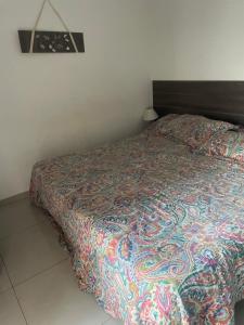 a bedroom with a bed with a colorful comforter at 37 Intendente Doctor Jaime Gil in Río Cuarto