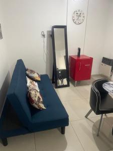 a blue couch in a room with a mirror at 37 Intendente Doctor Jaime Gil in Río Cuarto