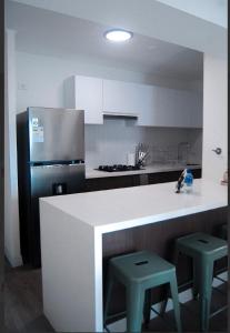 a kitchen with a white counter and two stools at Warm & Exclusive 2 BR in San Antonio