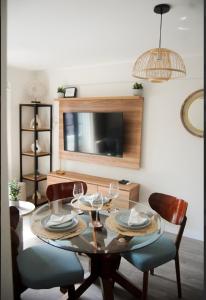 a dining room with a table with chairs and a television at Warm & Exclusive 2 BR in San Antonio +4 photos