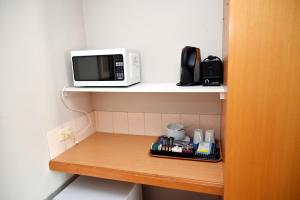 a microwave sitting on a shelf in a room at Paddlewheel Motel in Echuca