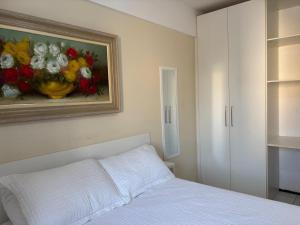 a bedroom with a bed and a painting of flowers at Praia Litorânea in São Luís +10 photos