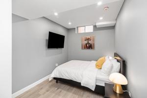 a bedroom with a bed and a flat screen tv at Cozy Spacious 2BR Suite with Parking & Wi-Fi in Hamilton