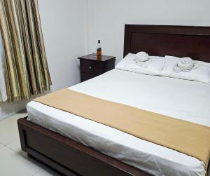 a bedroom with a large bed with a wooden headboard at Baywatch Beach Resort in Olongapo
