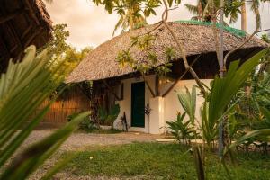 a small cottage with a thatched roof at Bamboo Jungle Villa's in El Nido
