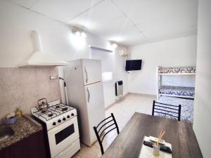 a kitchen with a table and a stove and a refrigerator at Gotas de Rocio N1 in San Antonio Oeste