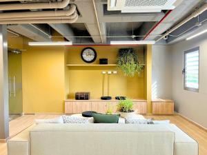 a living room with a couch and a clock on the wall at Exclusive Rodadero Sur Studio Apartment in Santa Marta