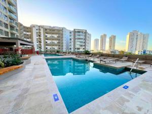 a large swimming pool in a city with tall buildings at Exclusive Rodadero Sur Studio Apartment in Santa Marta