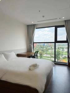 a bedroom with a bed with a desk and a window at HOMESTAY ADORA in Long Bình +269 photos