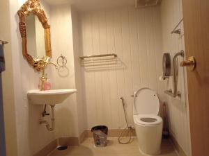 a bathroom with a toilet and a sink and a mirror at Casa Nicola BKK in Ban Na Song
