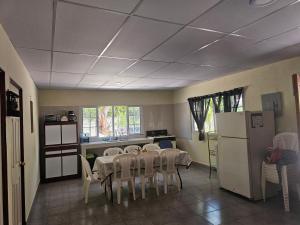 a kitchen with a table with chairs and a refrigerator at Honey Beach House in La Esmeralda