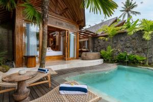 a villa with a swimming pool and a patio at Govala Usada Ubud Villa in Ubud