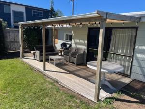 a wooden deck with a gazebo in a yard at Hosts on the Coast Ocean Corner in Whangamata