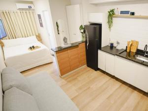 a living room with a couch and a kitchen at Apê Brooklin -Berrini in São Paulo