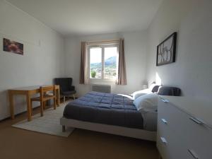 a bedroom with a bed and a desk and a window at Hostel du Canyon in La Palud-sur-Verdon