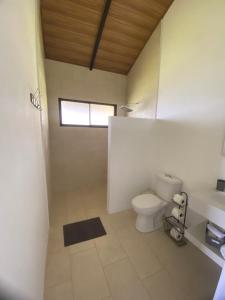 a bathroom with a toilet and a window at Cabaña Vistas de Lujo in Fraijanes