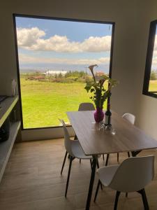 a dining room with a table and chairs and a large window at Cabaña Vistas de Lujo in Fraijanes