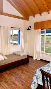 a bedroom with a bed and two windows at Quinta La Carlota in Navarro +22 photos