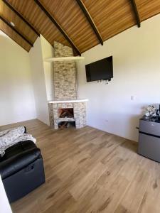 a living room with a fireplace and a flat screen tv at Cabaña Vistas de Lujo in Fraijanes