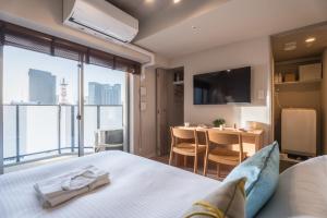 a hotel room with a bed and a dining area at ESLEAD HOTEL Namba East in Osaka