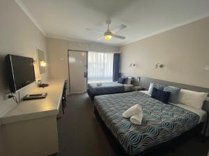 a hotel room with a bed and a television at Paddlewheel Motel in Echuca +30 photos