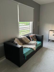 a black couch in a room with a window at Refugio Viajero in General Alvear +6 photos