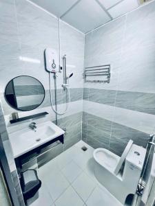 a bathroom with a sink and a toilet and a mirror at Hotel Đông Ngô Biên Hòa in Ấp Thành