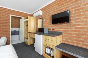 a room with a brick wall with a tv on the wall at Edithburgh Seaside Motel in Edithburgh
