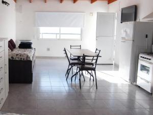 a kitchen with a table and chairs and a bed at Gotas de Rocío - para 4 en San Antonio Oeste in San Antonio Oeste +4 photos