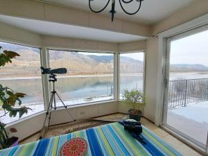 a bedroom with windows with a view of the water at Private Bedroom at Riverfront House in Kamloops