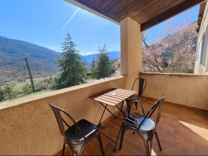 a table and chairs on a balcony with a view at Hostel du Canyon in La Palud-sur-Verdon