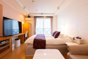 ein Hotelzimmer mit Bett und Fernseher in der Unterkunft Hotel Liberty Matsuyama (Adult Only) in Matsuyama