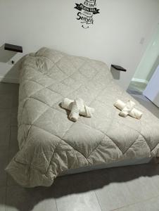 a bed with two pairs of slippers on it at Casa Ruta 3 Río Gallegos in Río Gallegos