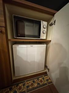 a microwave sitting on top of a refrigerator at ホテルロアール 大人専用 in Miyake +16 photos